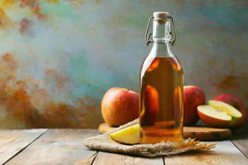 Apple vinegar. Bottle of apple organic vinegar or cider on wooden background. Healthy organic food....