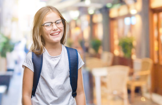 Young beautiful smart student girl wearing backpack over isolated background looking away to side with smile on face, natural expression. Laughing confident.