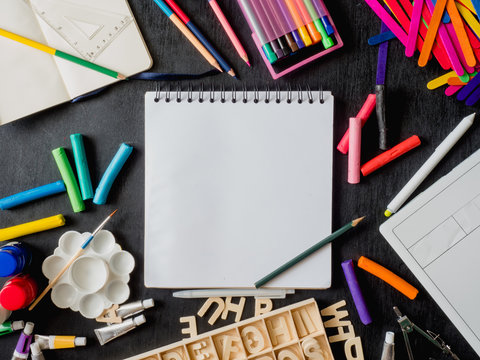 Back to school concept and artist kid concept with Drawing book, crayons, coloured pencils, Poster color and School stationery on wooden table background.