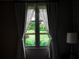 window old viallage garden view in the dark room.