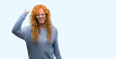Young redhead woman wearing glasses annoyed and frustrated shouting with anger, crazy and yelling with raised hand, anger concept