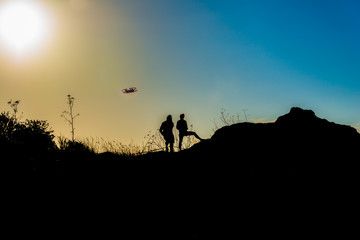 Fototapeta na wymiar Flying a drone at sunrise in silhouette
