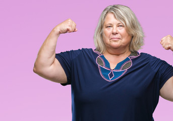 Senior plus size caucasian woman over isolated background showing arms muscles smiling proud. Fitness concept.