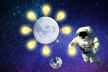 Obraz na płótnie Canvas astronaut an electrician replaces a light bulb on moon.space lighting.elements of this image furnished by NASA