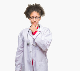 Young afro american doctor woman over isolated background looking confident at the camera with smile with crossed arms and hand raised on chin. Thinking positive.