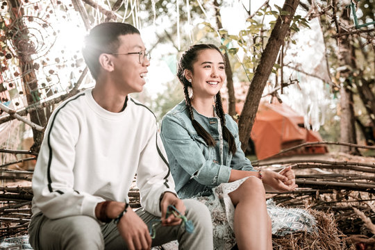 Asian couple. Pleased brunette female keeping smile on her face while enjoying nature