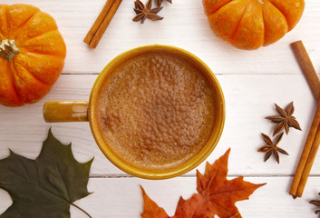Hot Pumpkin Latte on a White Wood Table with Fall Decorations