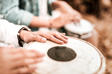 Close up. Young hippy making music while spending weekend in park