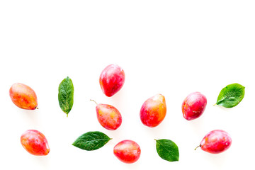 Summer harvest of red plum.  Red plum and leaves pattern on white background top view space for text