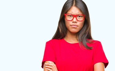 Young asian woman wearing glasses over isolated background skeptic and nervous, disapproving expression on face with crossed arms. Negative person.