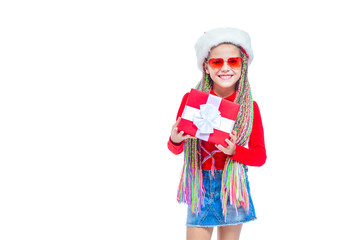 Girl in Santa's hat. Portrait of little cute girl holding box of Christmas present, Small girl hug her gift with happy and fun expression isolated on white background. Holiday gift