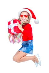 Obraz premium Girl in Santa's hat. Portrait of little cute girl holding box of Christmas present, Small girl hug her gift with happy and fun expression isolated on white background. Jump up. Holiday gift