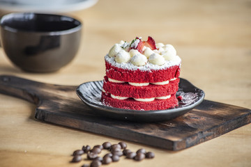 sweet strawberry cake  on the black plate near the coffee in the black cup