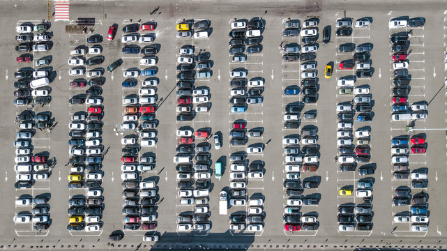 Aerial drone view of parking lot with many cars near shopping mall from above, city transportation and urban concept
