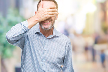 Middle age hoary senior business man over isolated background smiling and laughing with hand on face covering eyes for surprise. Blind concept.