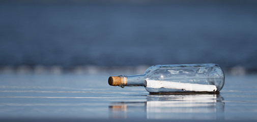 Message in a bottle found on the beach - obrazy, fototapety, plakaty