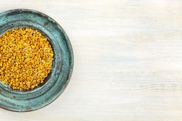 Bee pollen closeup, shot from above on a light background with copy space