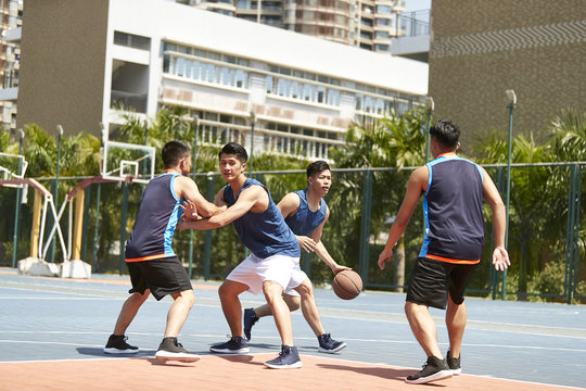 young asiian men playing basketball