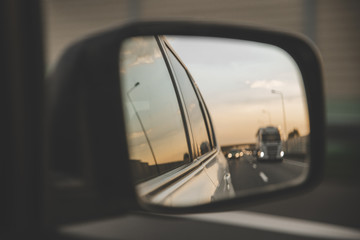 car on highway. sunset in car mirror reflection