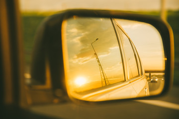 car on highway. sunset in car mirror reflection