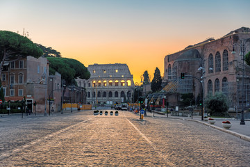 Fototapeta premium Wschód słońca w Rzymie, Włochy. Widok Koloseum od rzymskiej ulicy rano Rzym Włochy.