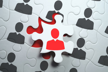 Think different and unique concept. Selecting right people for organization's success.  Jigsaw puzzle piece with red businessperson standing out from the crowd.