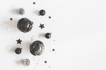 Christmas composition. Christmas black and silver decorations on pastel gray background. Flat lay, top view, copy space