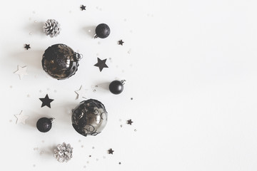 Christmas composition. Christmas black and silver decorations on pastel gray background. Flat lay,...