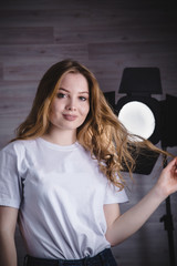 Fototapeta premium Girl in white tee-shirt in studio near spotlights