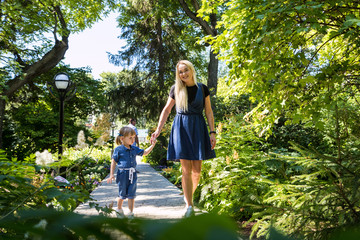 Fototapeta premium Cute blonde woman and her daughter in the park