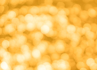 Obraz premium Yellow bokeh background texture. Golden blurred bright glare of light texture