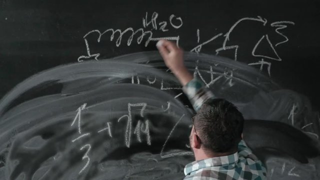 A brilliant mature mathematician brings a big board and completes an essay Complicated mathematical formula equation