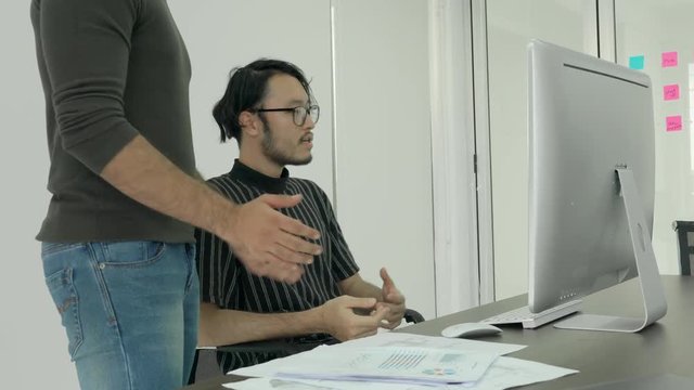 Designer artist explaining ideas to creative manager and meeting together, middle east or transcontinental region centered on western asia. Concept of employee design and development.