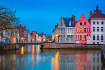 Scenic city view of Bruges canal with beautiful medieval colored houses, bridge and reflections in the evening, Belgium
