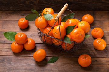 Fresh mandarin oranges fruit or tangerines with leaves in a basket © Nitr