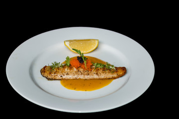 Fish in a white plate, black background