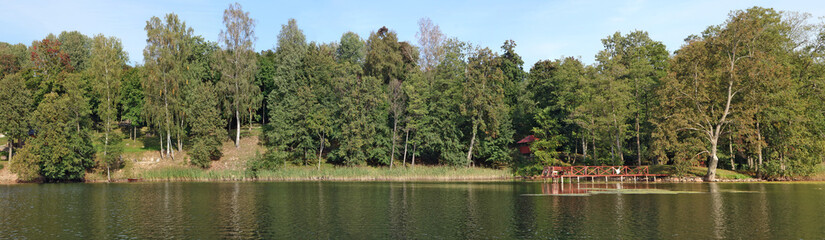 A typical rural Lithuanian landscape is a cold lake  coast, birch  forest  and a wooden bath and pier  on the shore