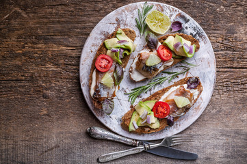 Sandwiches with smoked mackerel, avocado and red onion. Top view