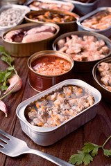 group of open cans of seafood on wood