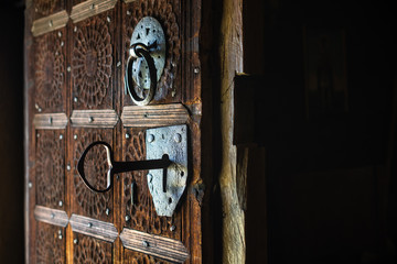 Big key in rustic door of wooden church