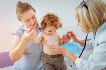 Friendly doctor pediatrician with patient child at clinic