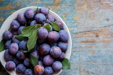 Fototapeta premium Plum plate on wooden background.