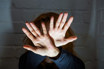 a woman tries to fend off an attack with her hands
