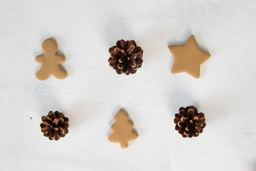 holidays, winter and celebration concept - Christmas composition. pine cones, gingerbread on white background. Flat lay, top view.