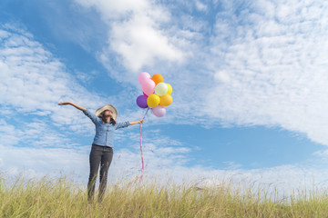 Young beautiful woman holding colorful air balloons in the park.  Relaxation on international women 's day