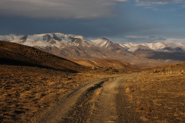 Fototapeta na wymiar Mountain stone rocky extreme road path on the background of high snow glacier ranges