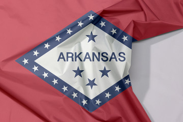 Arkansas fabric flag crepe and crease with white space, The states of America, A field of red and white diamond, bordered by blue and the word 'Arkansas' and stars.