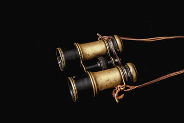 Old binoculars on dark background