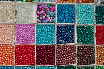 close up multi colored beads heap in box