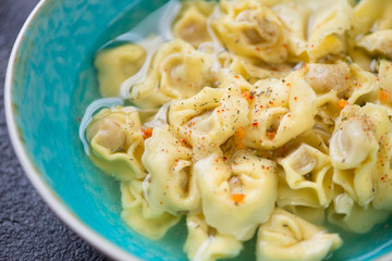 Closeup of italian tortellini served in bouillon, selective focus, studio shot